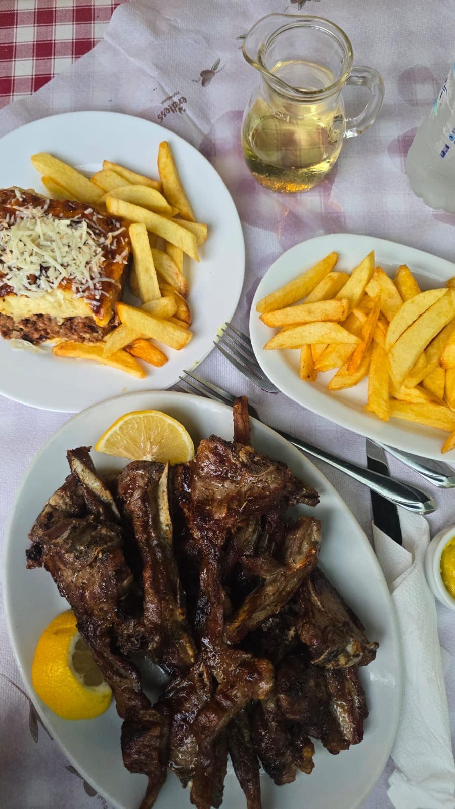 Lamb chops, moussaka and chips with a carafe of white wine at O Foros