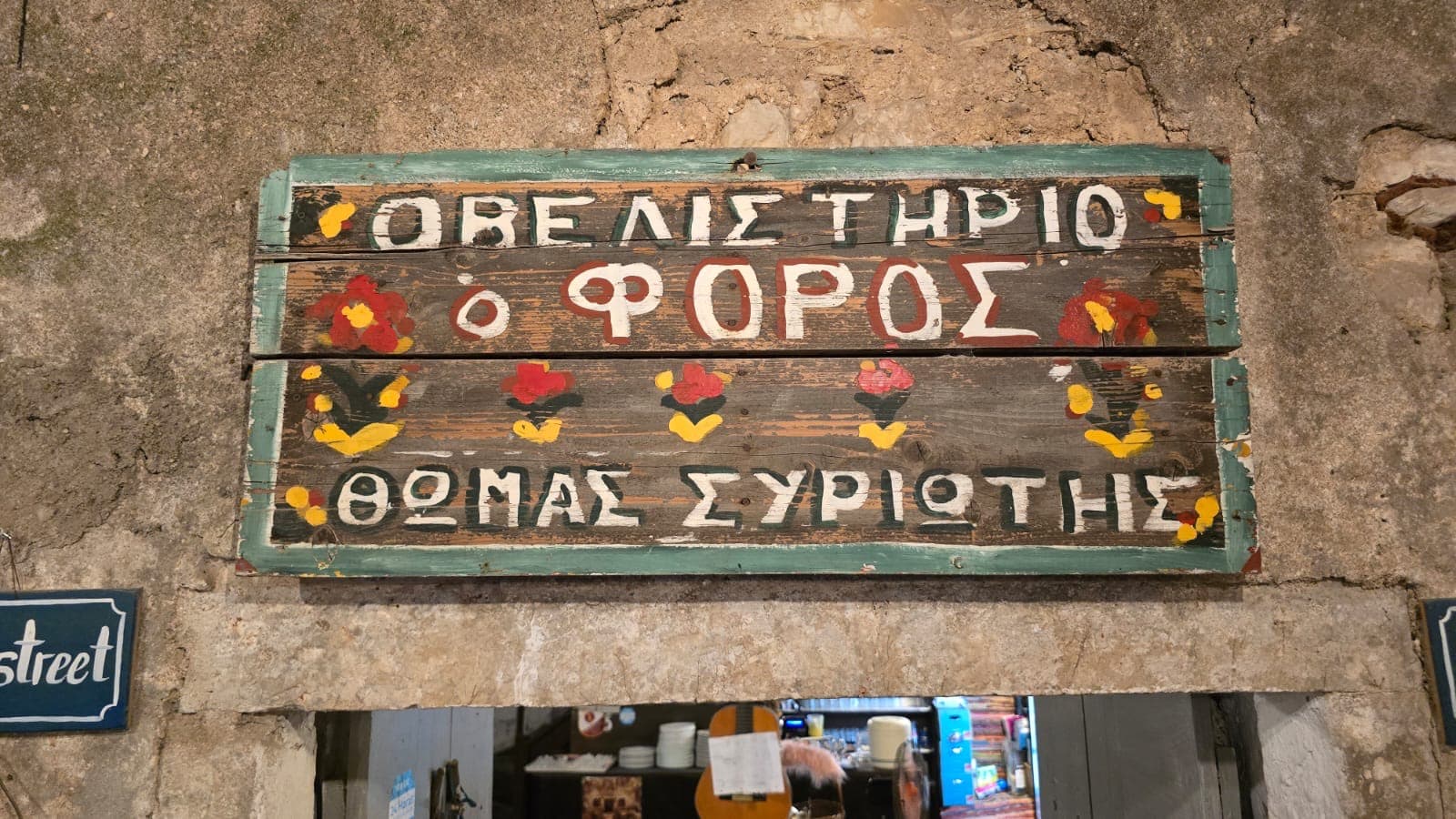 The hand-painted sign of the taverna O Foros in Old Perithia, Corfu
