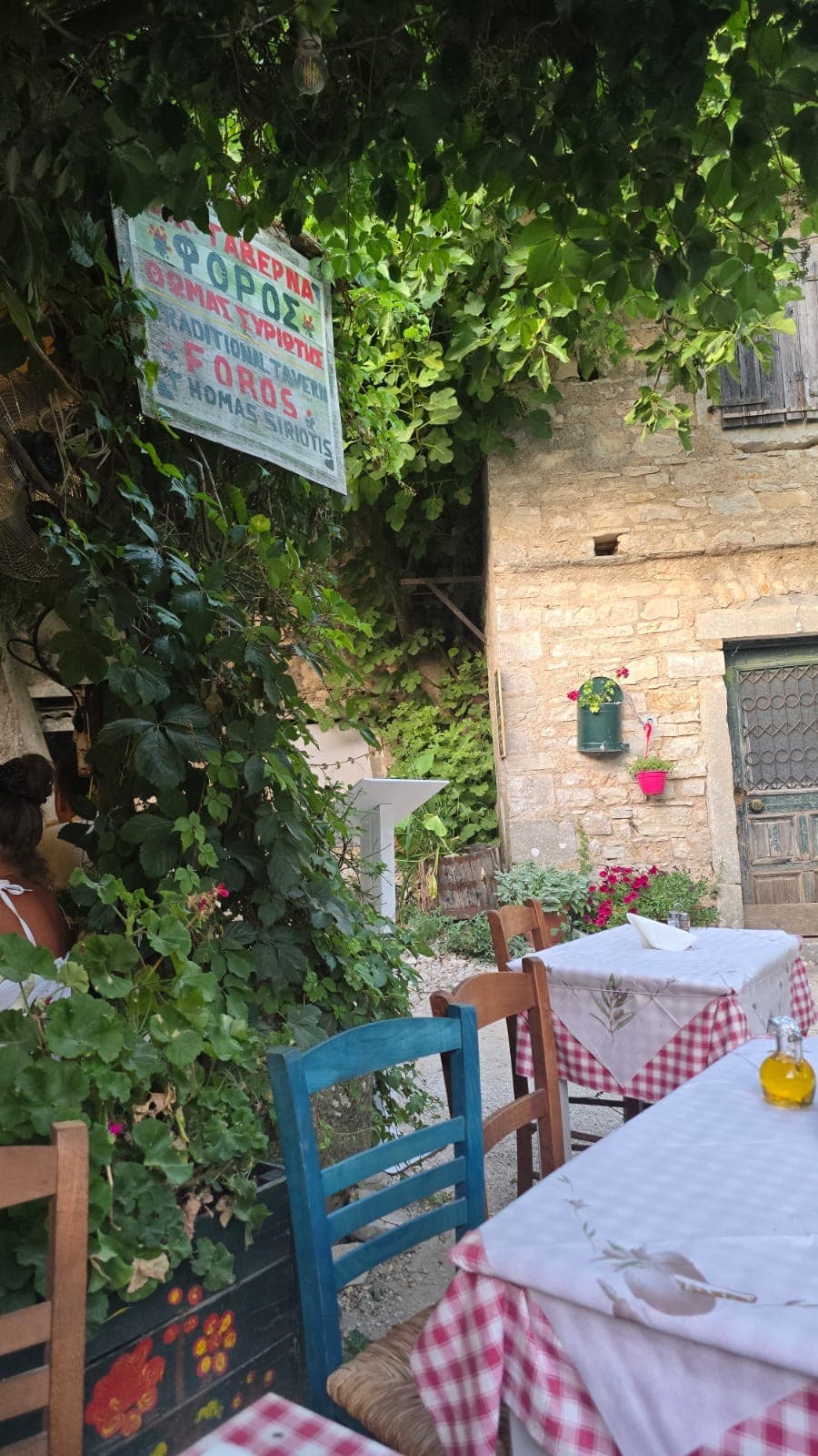 Tables set outside on the square at Old Perithia against a stone house